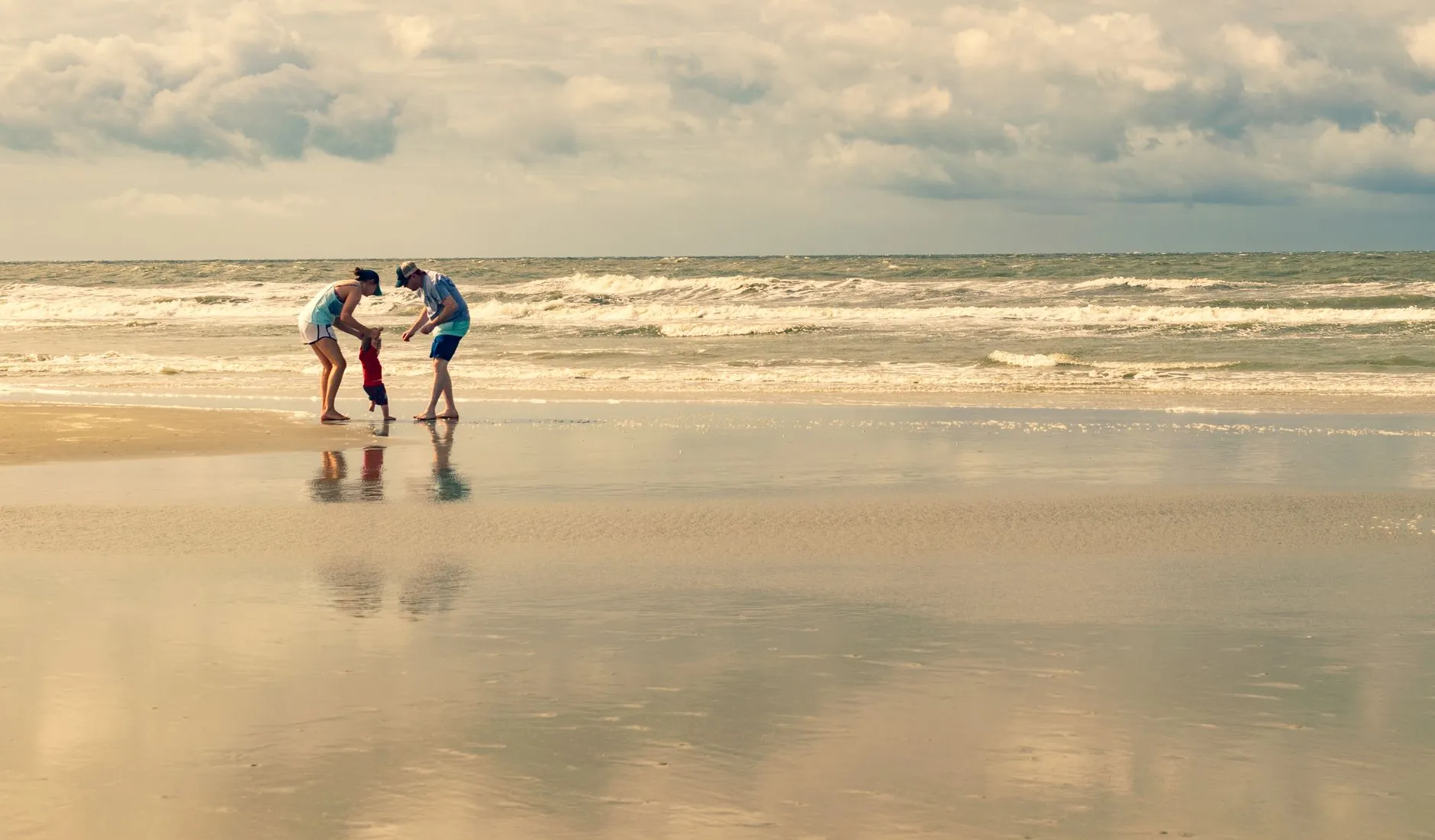 Família a desfrutar de um dia calmo numa praia de águas pouco profundas