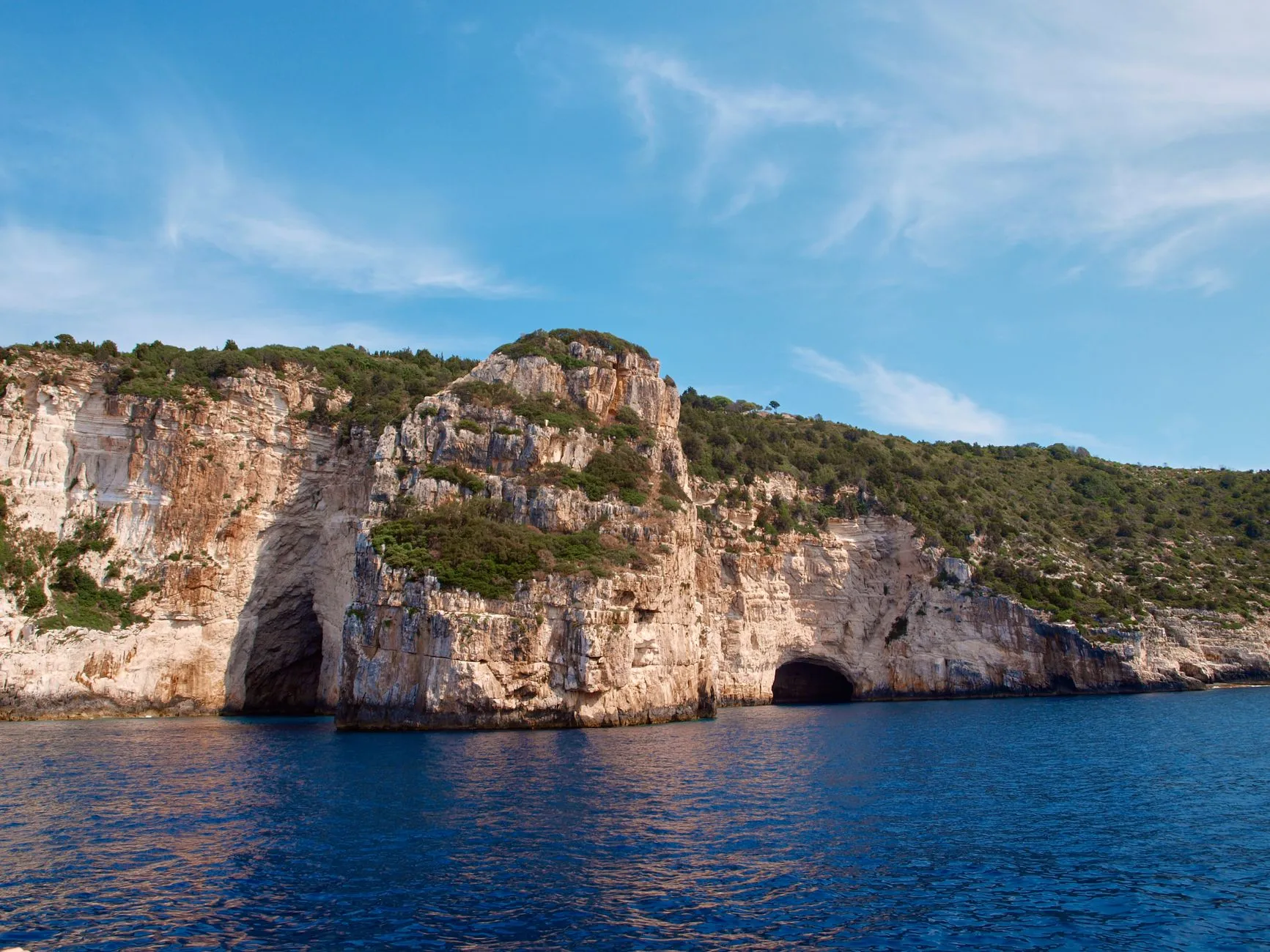 Experience the breathtaking beauty of Antipaxos' coastal cliffs with their stunning blue waters and rugged terrain.
